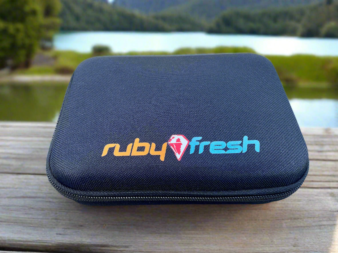 Black carrying case with 'ruby fresh' logo on a wooden surface with a lake and trees in the background