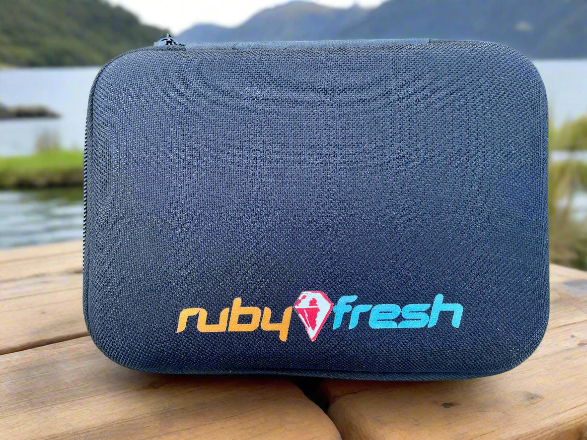 Black goggle case with 'ruby fresh' logo on a wooden surface by a lake